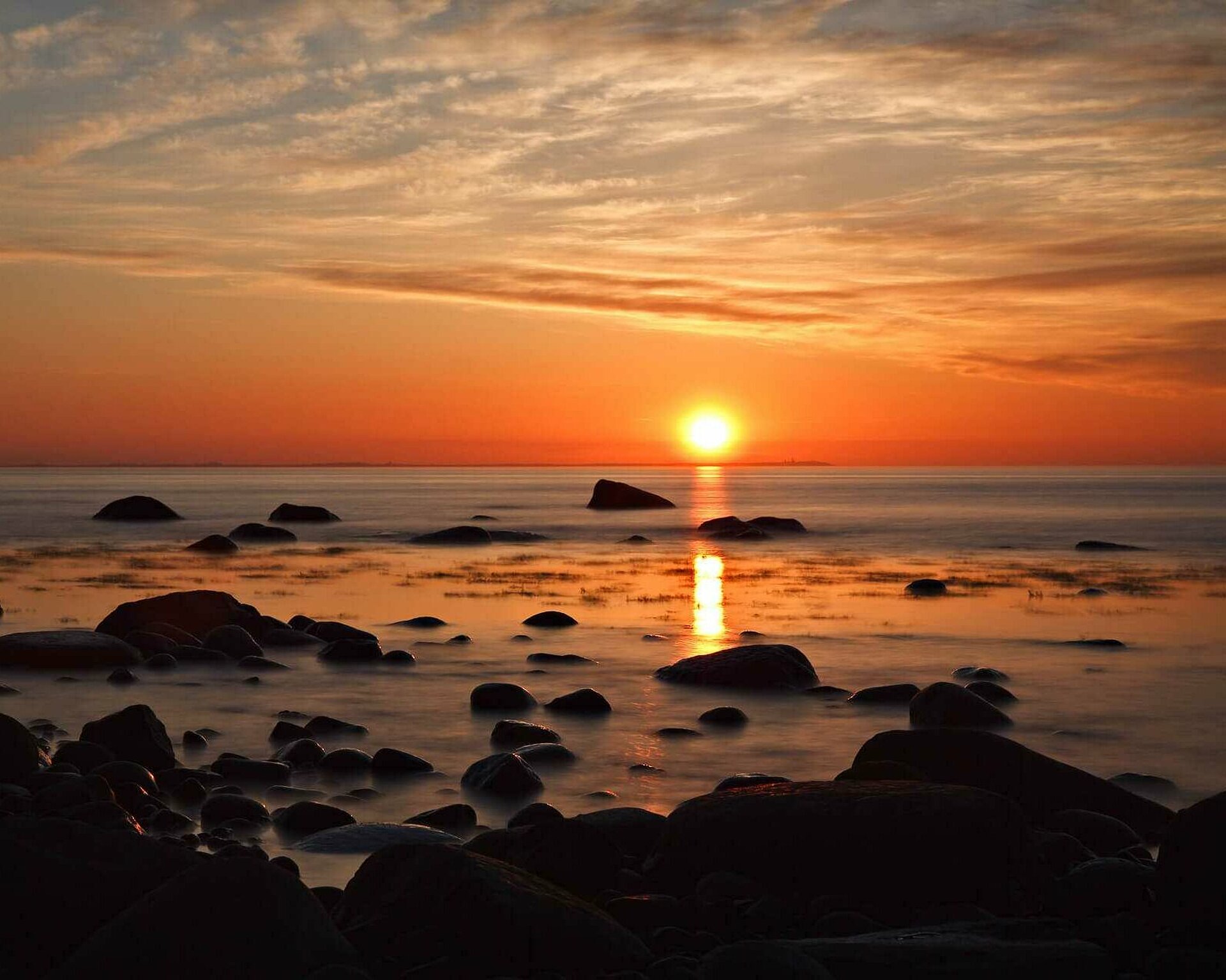 Sonnenuntergang mit Blick auf Meer und Steinstrand