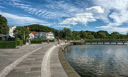 Schmachter See Promenadenplatz mit Sitzbänken und Seebrücke - Pension Anker, Rügen