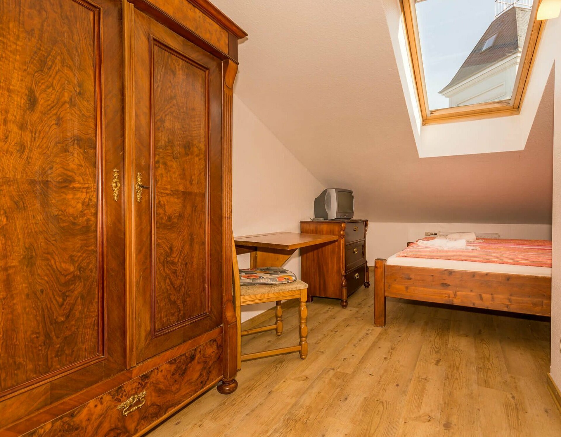 Einzelzimmer mit Bett und kleiner Sitzecke, Kabel-TV in Pension ANKER