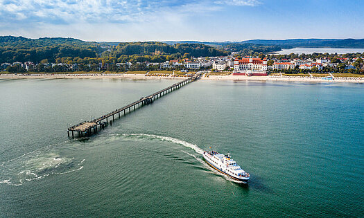 Luftaufnahme Binzer Bucht mit ablegenden Schiff von Seebrücke - Pension Anker, Rügen